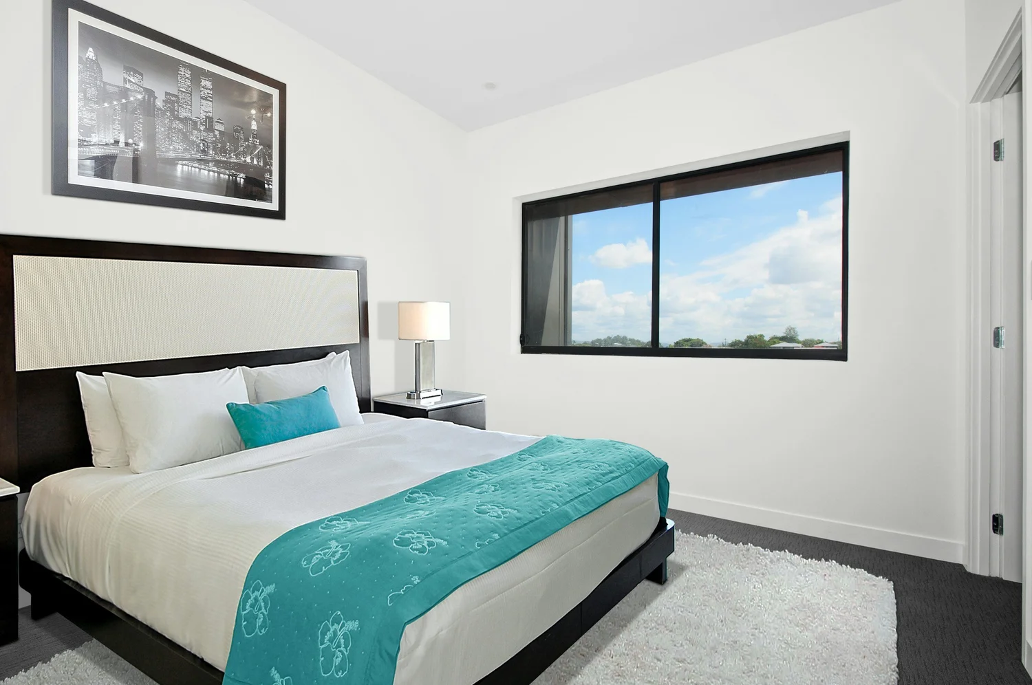 King bed made up in white and turquoise