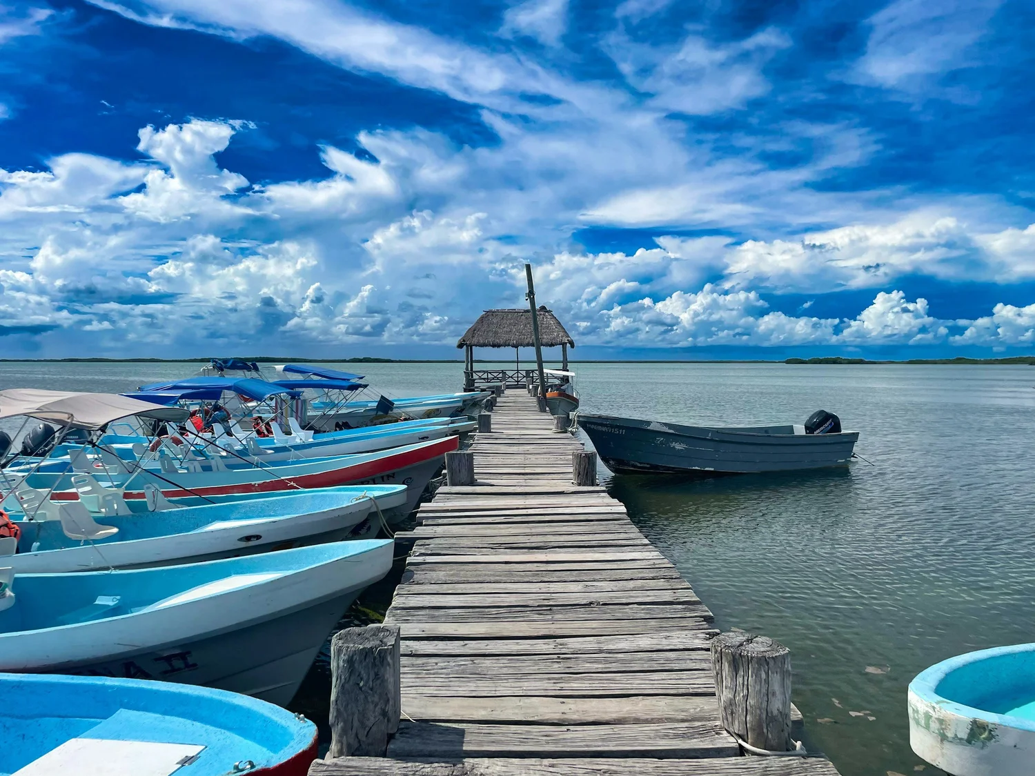 Wooden dock at the retreat with skiffs tied alongside