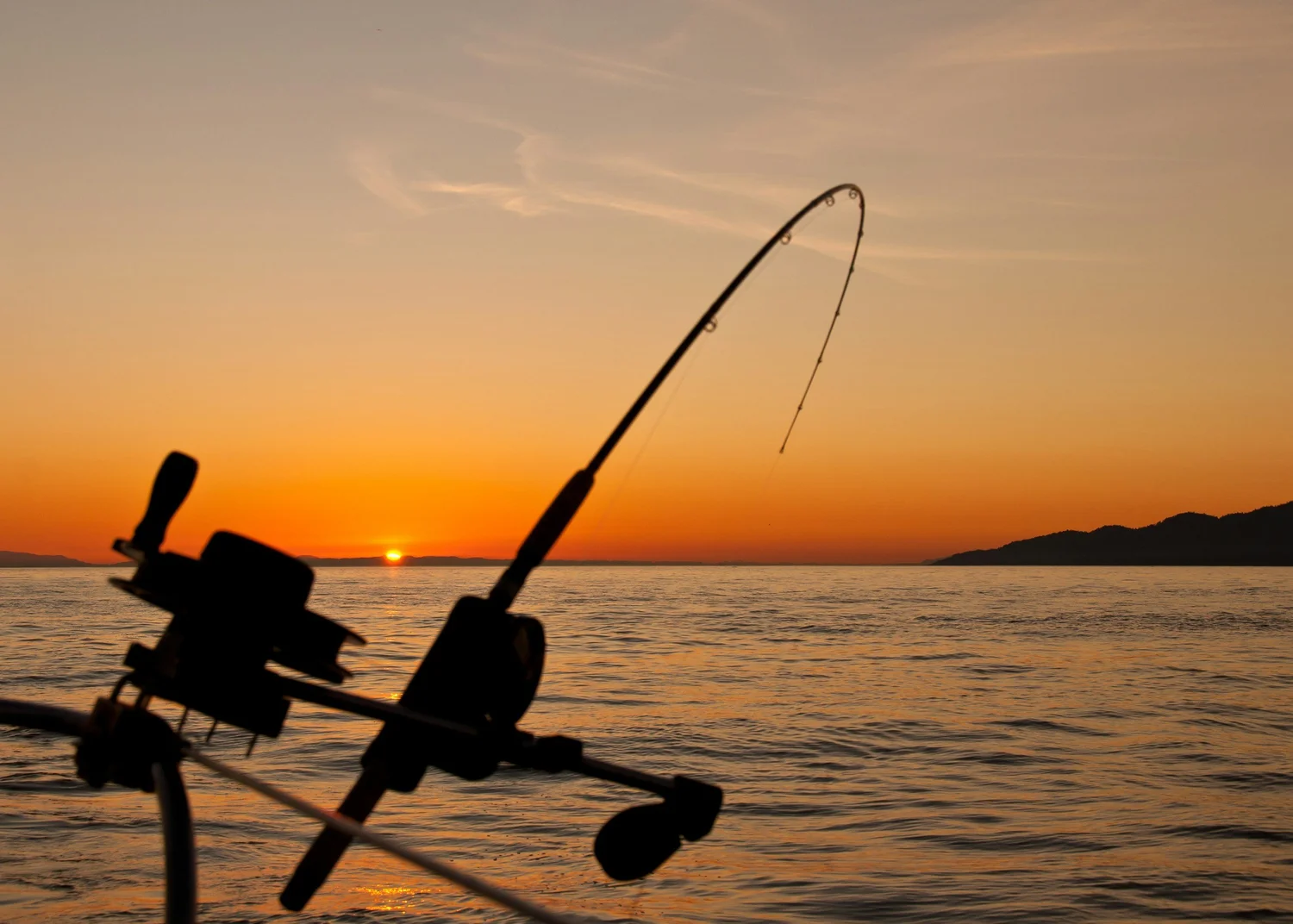 Fishing rod silhouetted against an Andros sunset